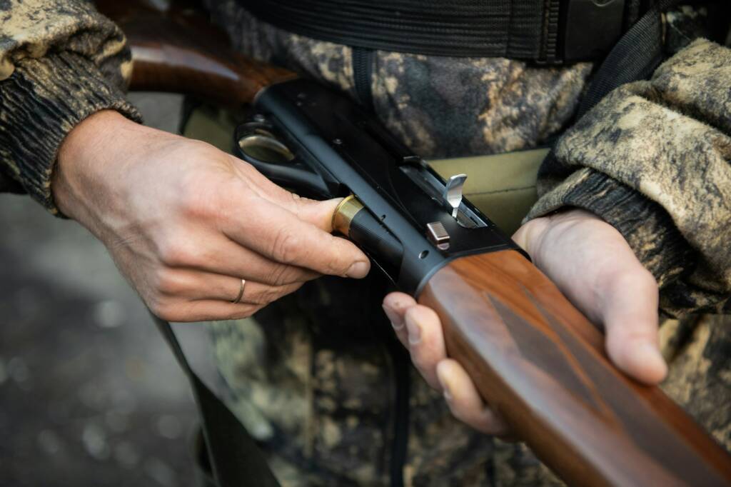 Close-up of a hunter hands loading his shotgun