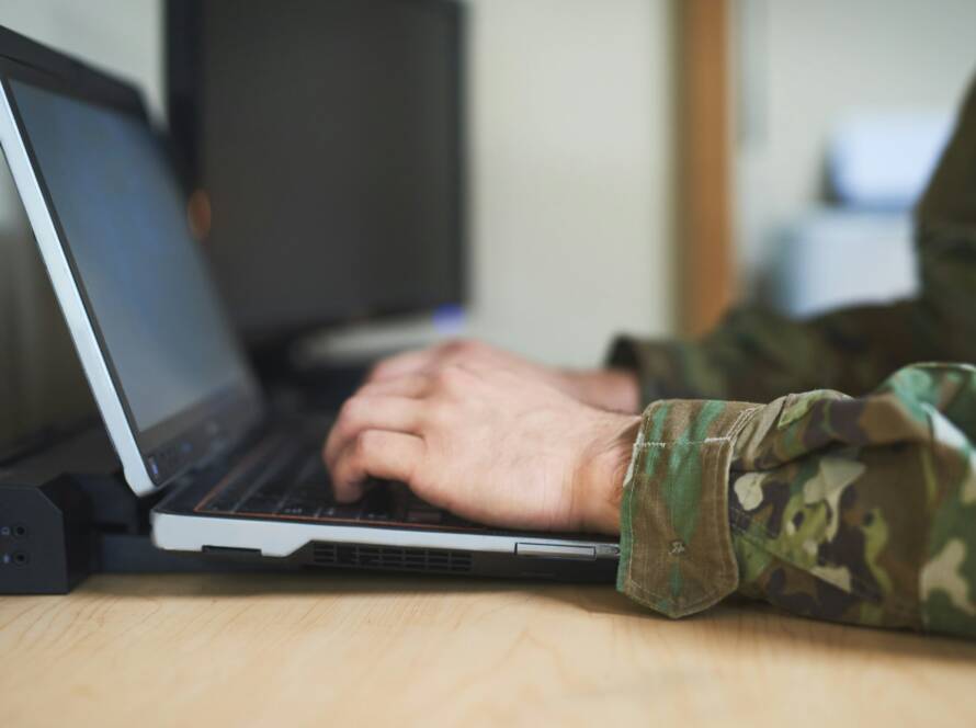 Cropped shot of a soldier using a laptop in the dorms of a military academy